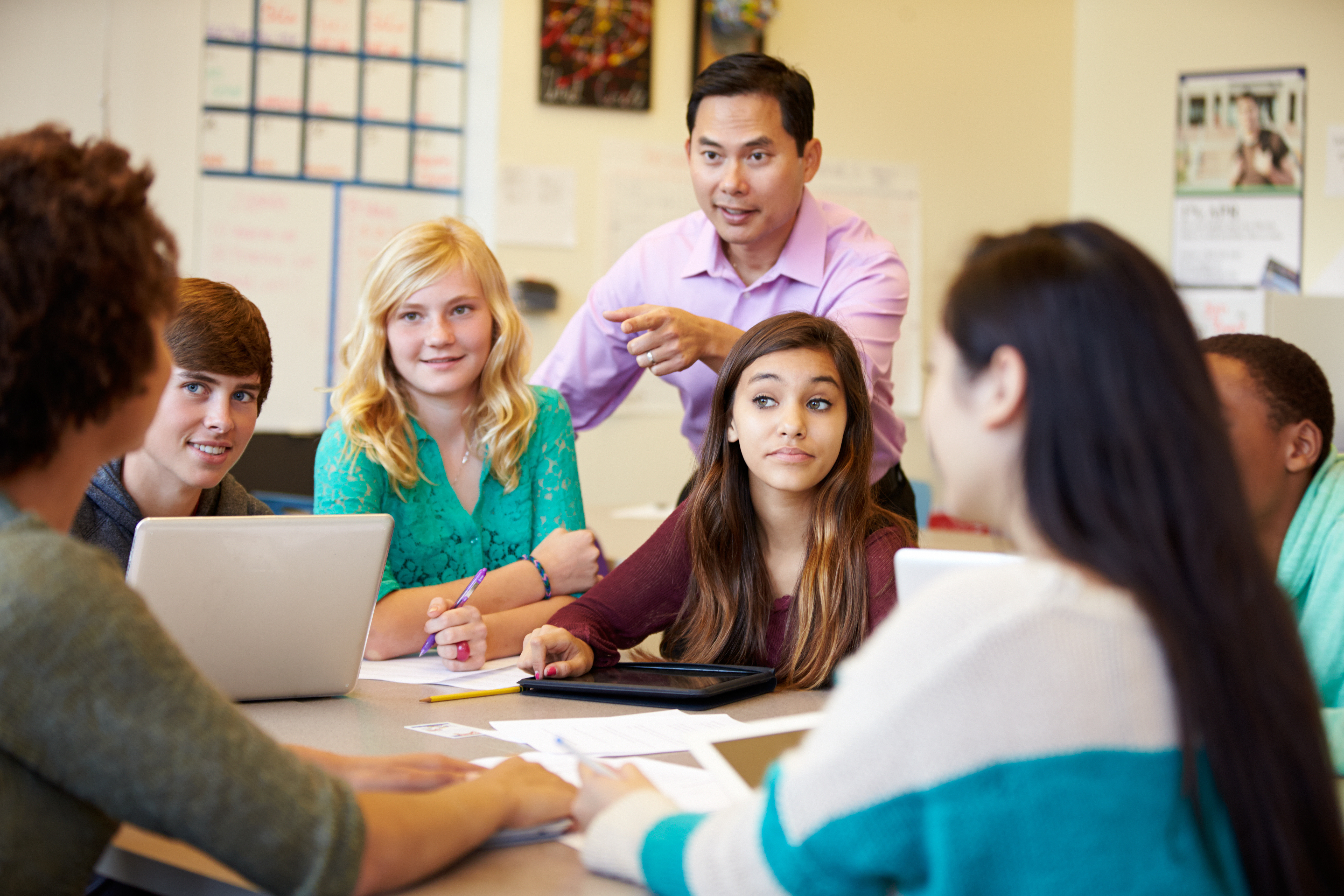 male teacher leads small group of middle school students